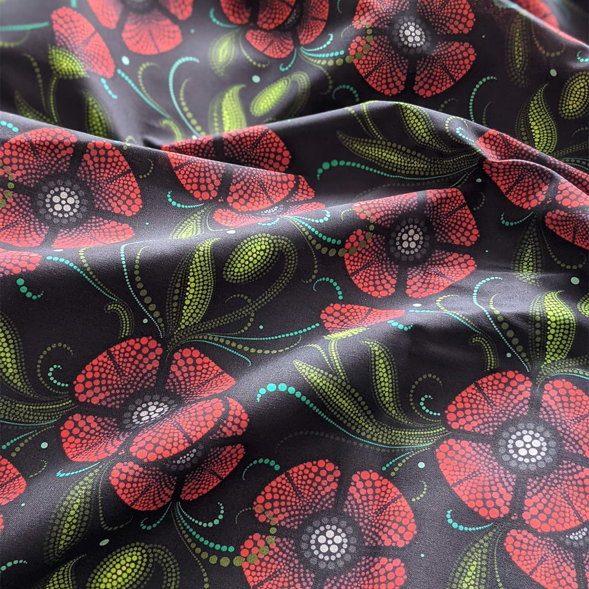 Indigenous Nouveau fabric featuring stylized red poppies on a black background