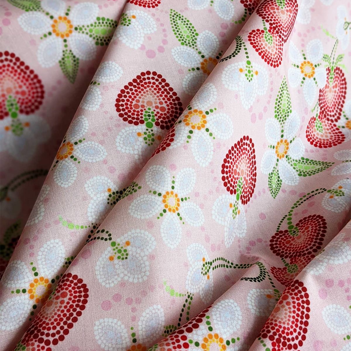 Indigenous Nouveau fabric featuring stylized red strawberries on a pink background