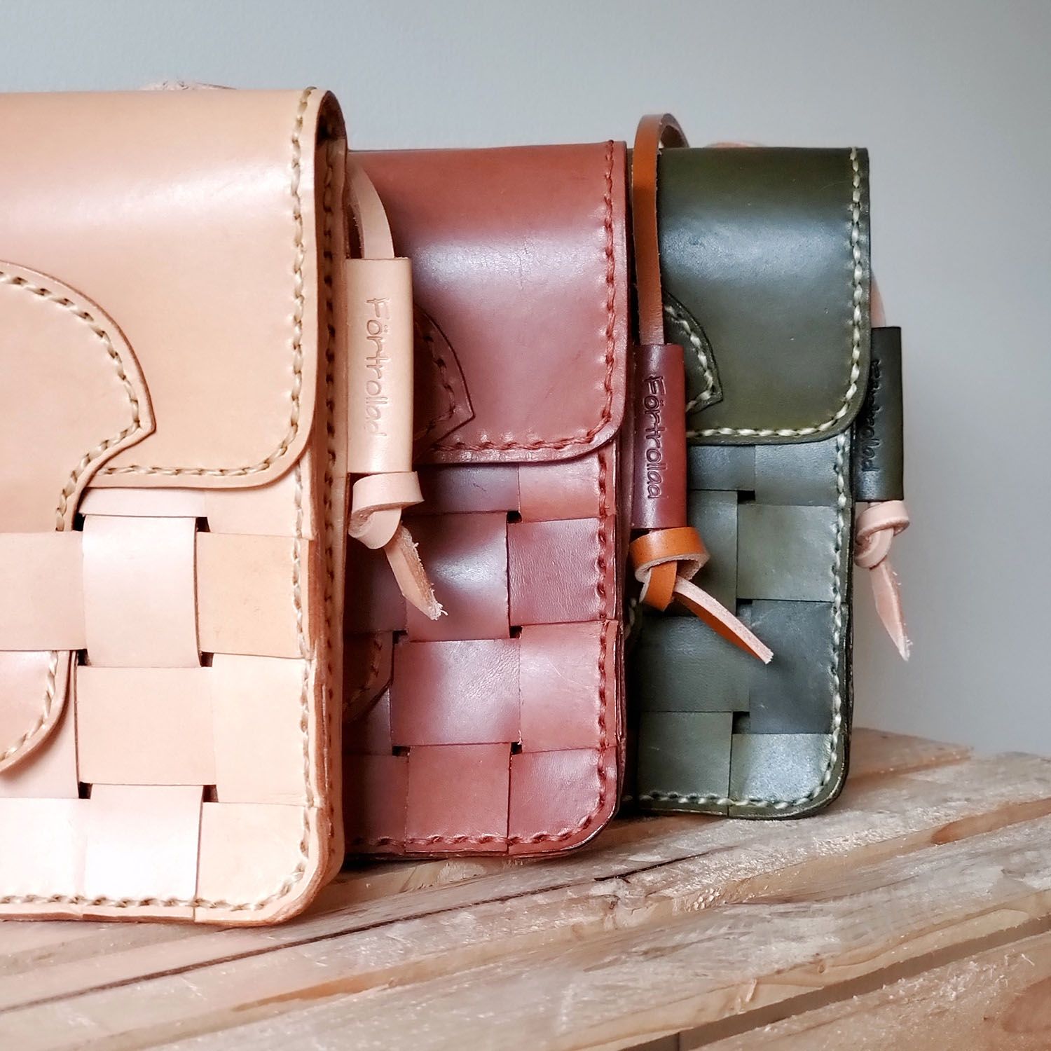 Three braided leather bags on a table