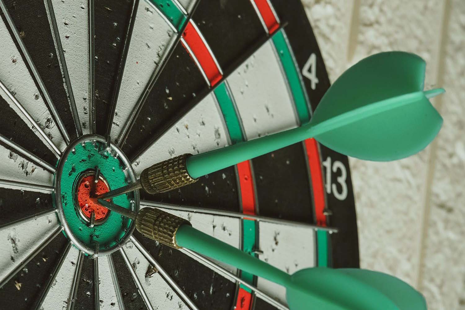 Close-up of a dart board with two darts in the bull's eye