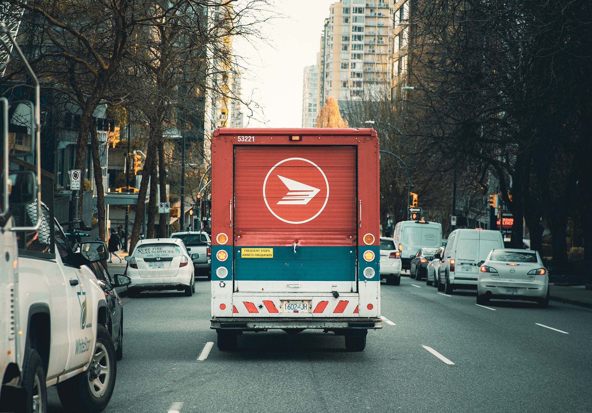 A Canada Post truck driving down a street in Vancouver