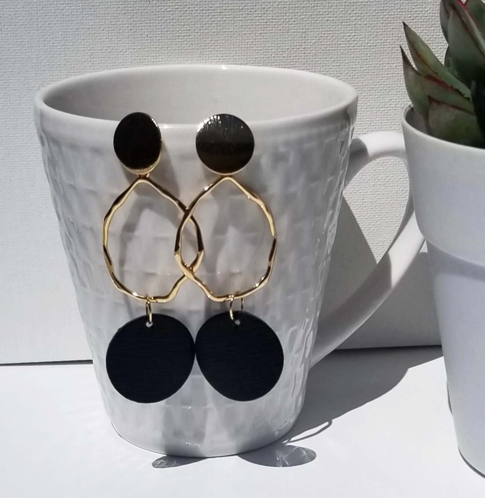 Earrings hanging on a white mug