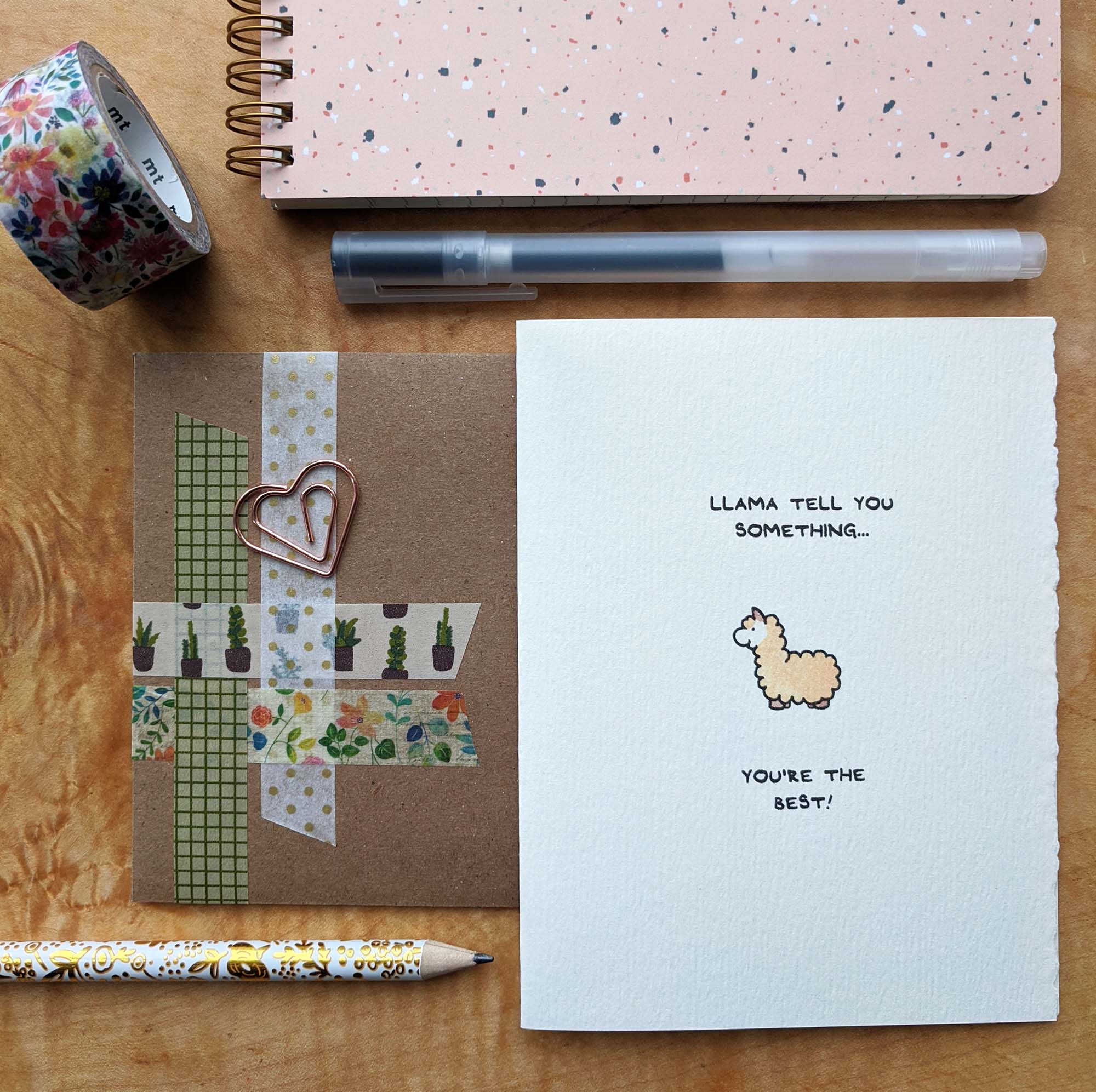 greeting card on a table with pencil, pen, notebook and tape